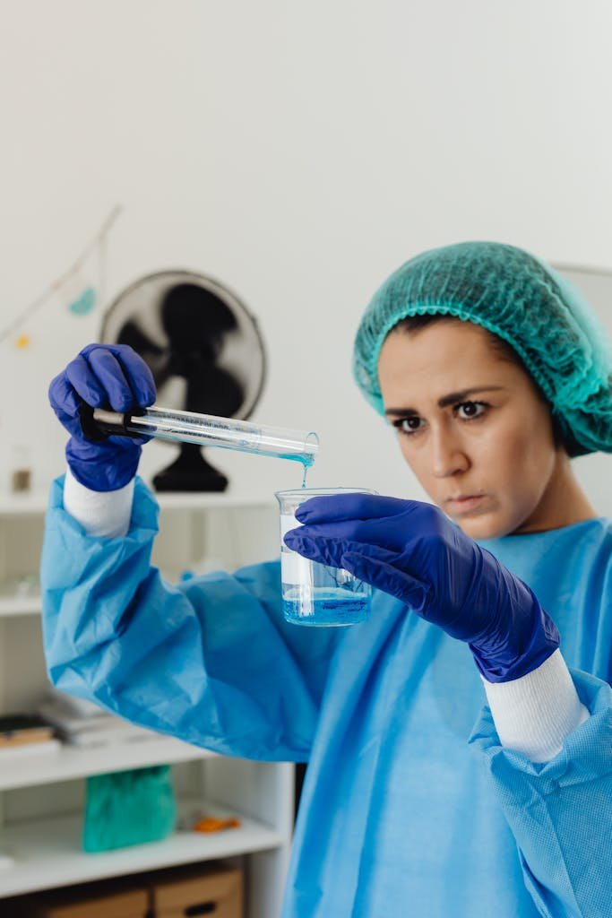 A scientist meticulously examining a beaker with liquid in a laboratory setting.